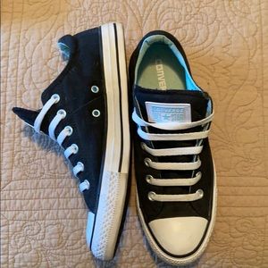 Black low top converse shoes. light blue inside